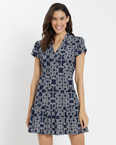Front view of a smiling model in the Jude Connally Emerson Dress - Lattice Ropes Navy