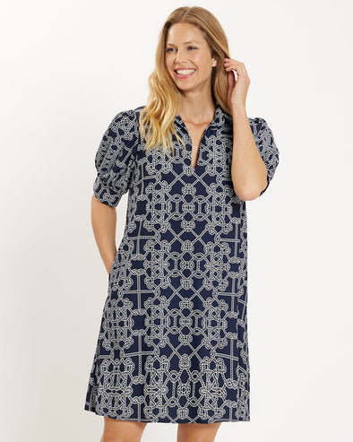 Front view of a smiling model in the Jude Connally Emerson Dress - Lattice Ropes Navy