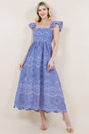 Blonde model wearing a long periwinkle dress with a stunning lace pattern and flutter sleeves