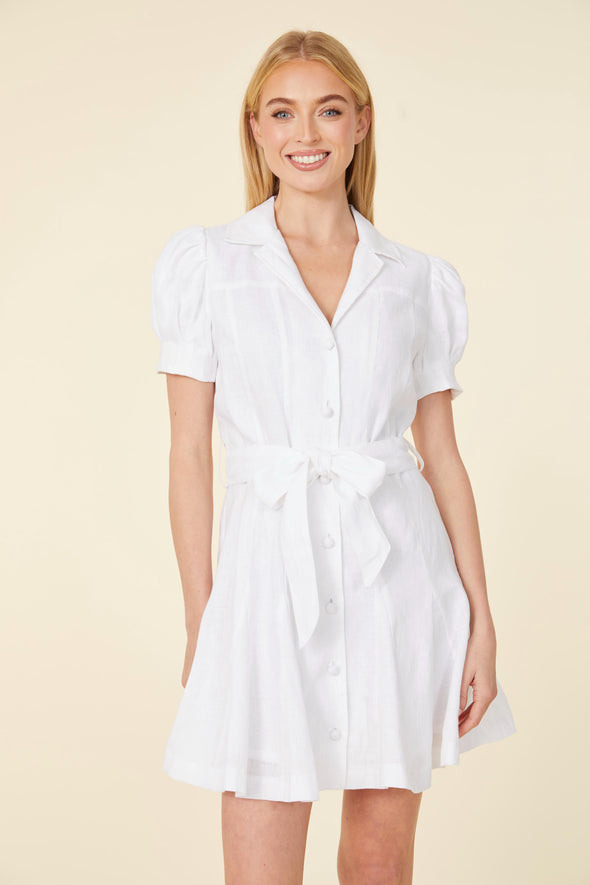 Smiling model in a short white dress with a collar, buttons down the front, puff sleeves, and a belt