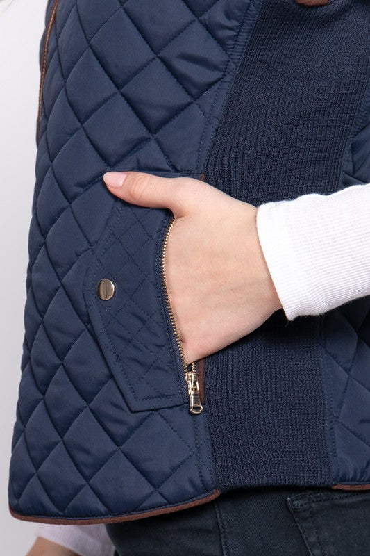 Close up of hand in a navy blue vest pocket and white long sleeve shirt