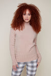 Red haired woman in beige sweater with plaid pants 